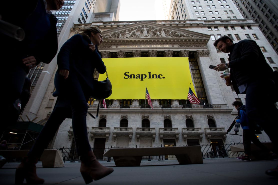 Pedestrians pass in front of Snap Inc. signage displayed on the exterior of the New York Stock Exchange during the company's initial public offering in 2017.