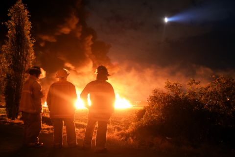 Firefighters stand at the scene of the explosion January 18 in Tlahuelilpan. 