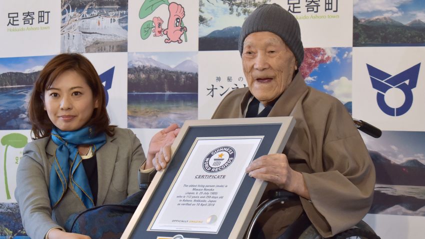 TOPSHOT - Masazo Nonaka of Japan (R), aged 112, receives a certificate for the Guinness World Records' oldest male person living title from Erika Ogawa (L), vice president of Guinness World Records Japan, in Ashoro, Hokkaido prefecture on April 10, 2018. - Nonaka was born on July 25, 1905. (Photo by JIJI PRESS / JIJI PRESS / AFP) / Japan OUT        (Photo credit should read JIJI PRESS/AFP/Getty Images)