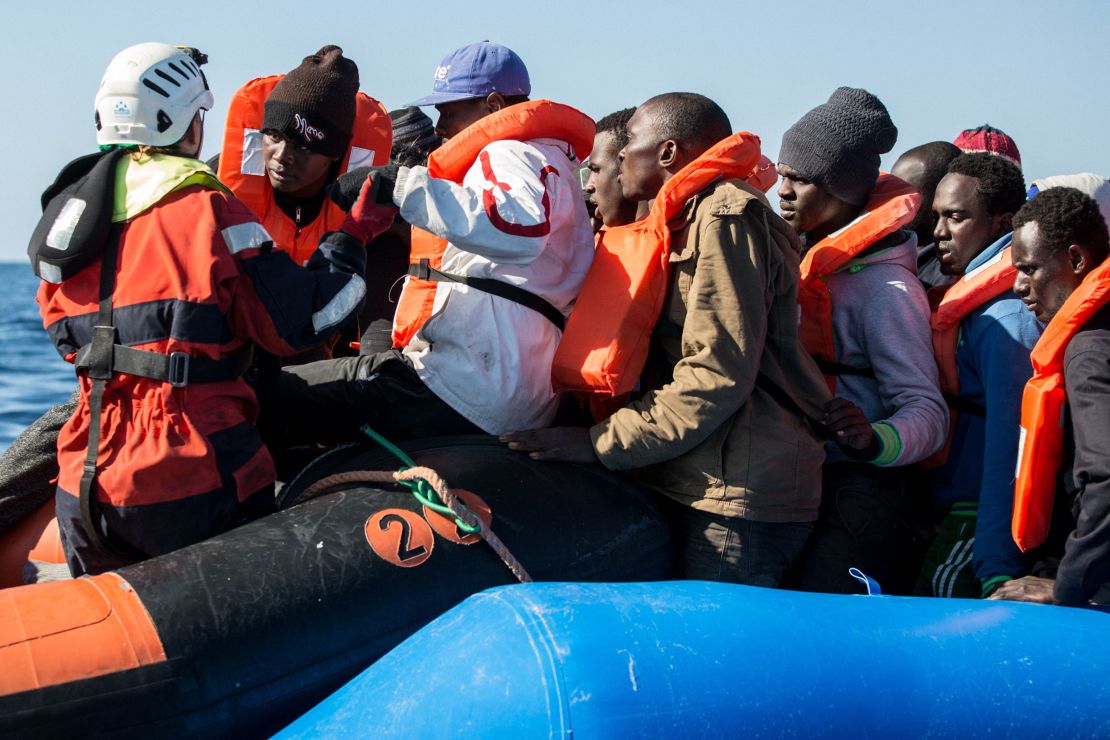 A group of 47 migrants is helped by a Sea Watch 3 crew member (left) during a rescue operation off Libya in January 2019. 