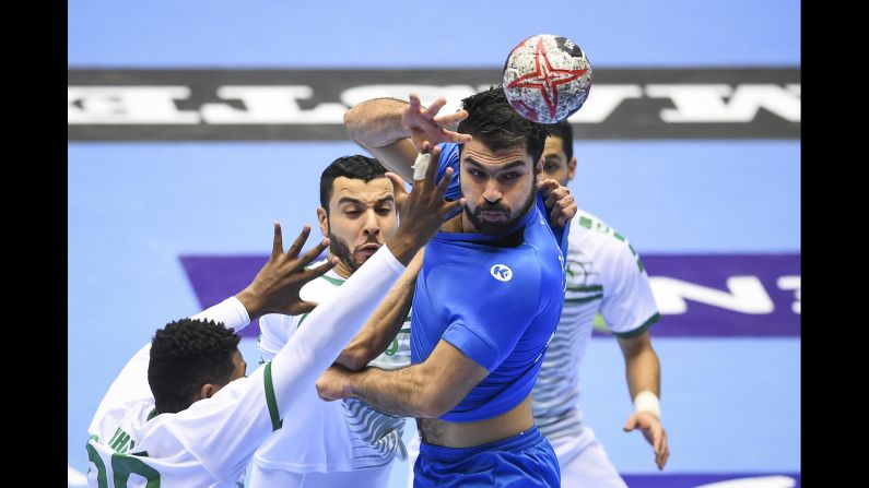 Tunisia's Oussama Jaziri competes with three Saudi Arabia players during an IHF Men's World Championship handball match on Tuesday, January 15.