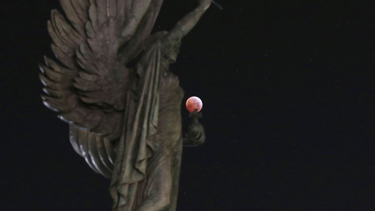 The blood moon with a statue in Brighton, England.
