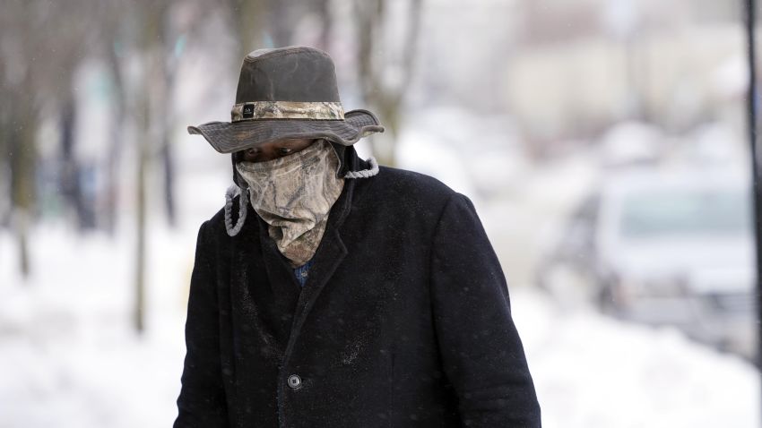 Marvin Hooks wears a face mask to protect him from the cold as he walks on North Street in Pittsfield, Mass., Monday, Jan. 21, 2019. Bitter cold and gusty winds swept across the eastern U.S. Monday with falling temperatures replacing the weekend's falling snow. (Ben Garver/The Berkshire Eagle via AP)