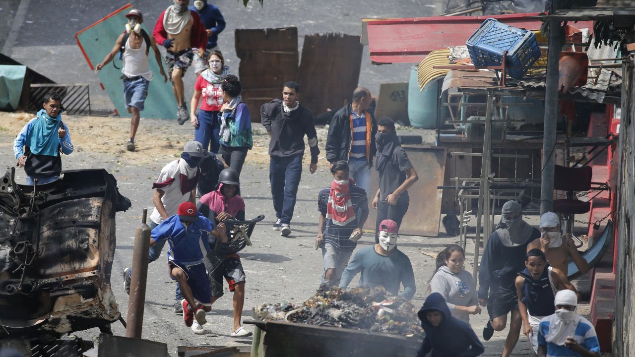 Anti-government protesters clash with security forces as they show support for an apparent mutiny by a national guard unit in the Cotiza neighborhood of Caracas, Venezuela, Monday, Jan. 21, 2019. The uprising triggered protests which were dispersed with tear gas as residents set fire to a street barricade of trash and chanted demands that President Nicolas Maduro leave power. (AP Photo/Ariana Cubillos)