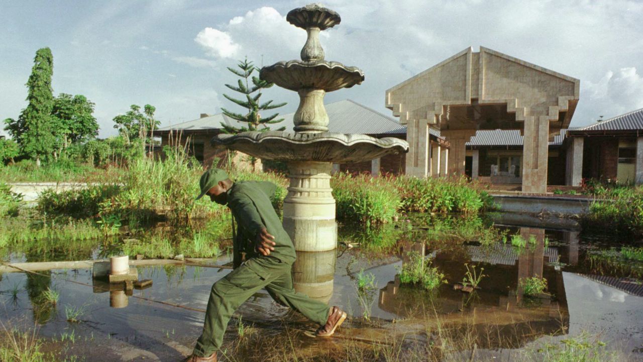 A soldier steps across an overgrown fountain in front of one of the late Mobutu Sesse Seko's palaces September 15, 2000 in Gbadolite, Congo. All three of the elaborate palaces in Gbadolite have long been looted.