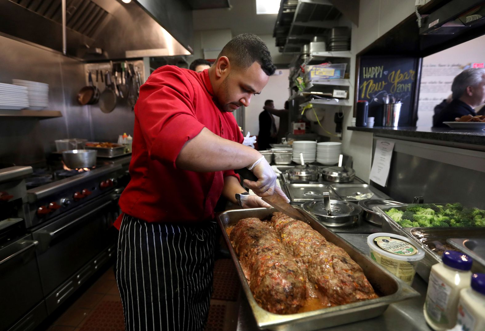 Chef Joshua Wiggins cuts portions of meatloaf for furloughed federal workers in Red Bank, New Jersey, on Monday, January 21. The free lunch was served at JBJ Soul Kitchen, the restaurant of rock star Jon Bon Jovi.