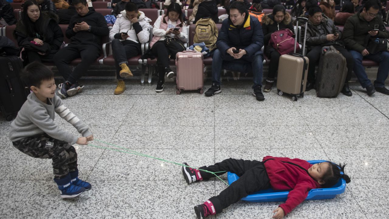 <strong>What stress?:</strong> Unlike adults, kids just don't seem to be affected by the stresses of travel, as this pair demonstrates at the Harbin Railway Station. 