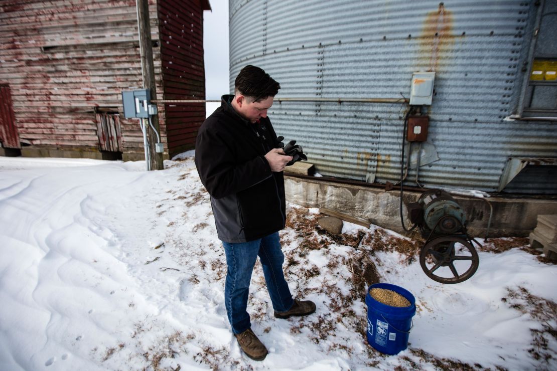 Brian Wolken, a farmer as well as mayor of Monticello, checks soybean subsidies on his phone. 