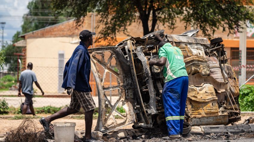 Scrap metal collectors salvages sellable parts from a car shell burnt during the three days protests in Emakhandeni township, in Bulawayo, on January 17, 2019. - Nationwide demonstrations erupted on January 14 following a crippling strike over the increase in the price of fuel announced by Zimbabwean President to tackle a shortfall caused by increased demand and "rampant" illegal trading. (Photo by ZINYANGE AUNTONY / AFP)        (Photo credit should read ZINYANGE AUNTONY/AFP/Getty Images)
