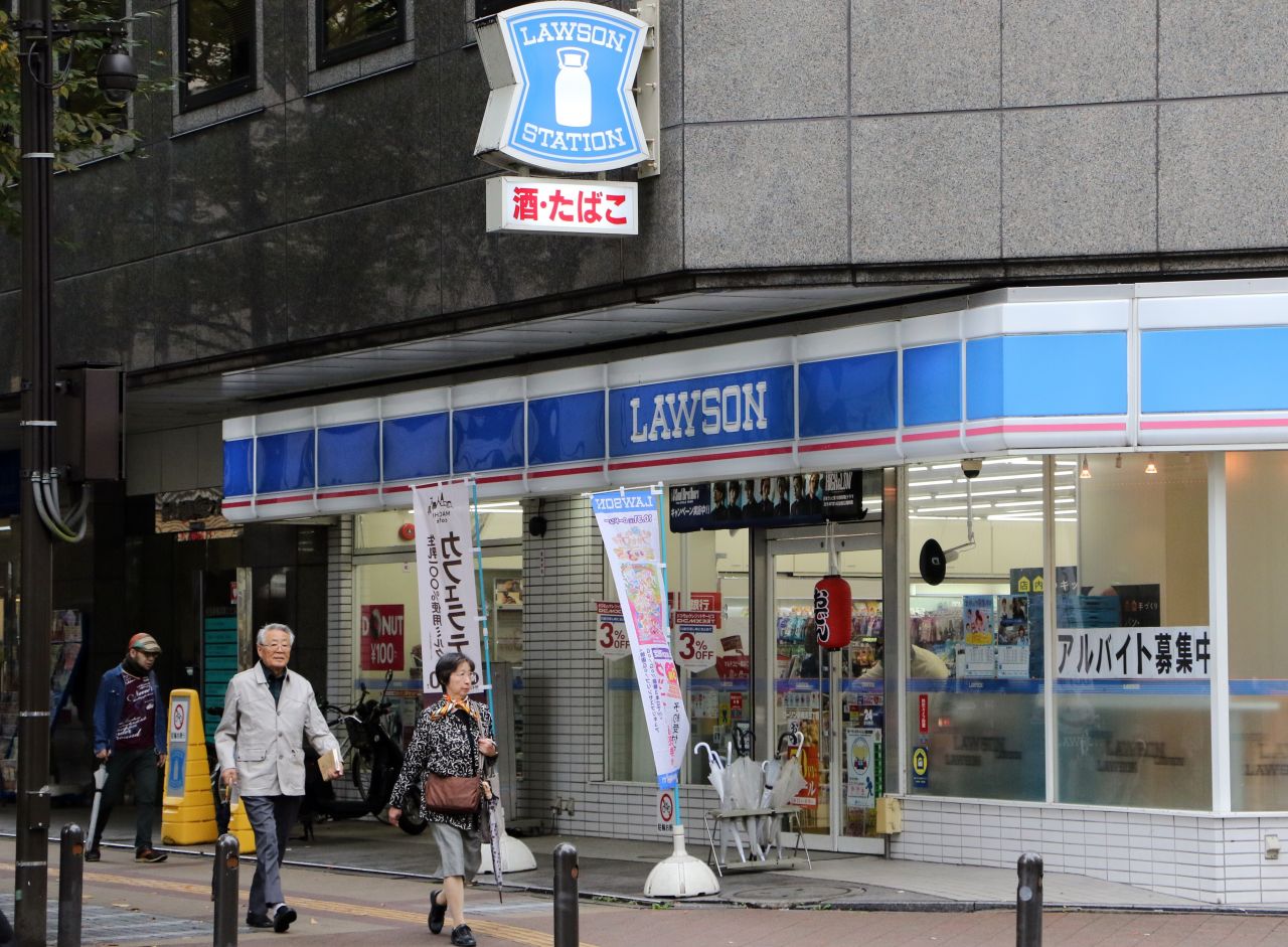 This 2015 image shows pedestrians walking past an outlet of Japan's second largest convenience chain, Lawson, in Yokohama, near the capital Tokyo.