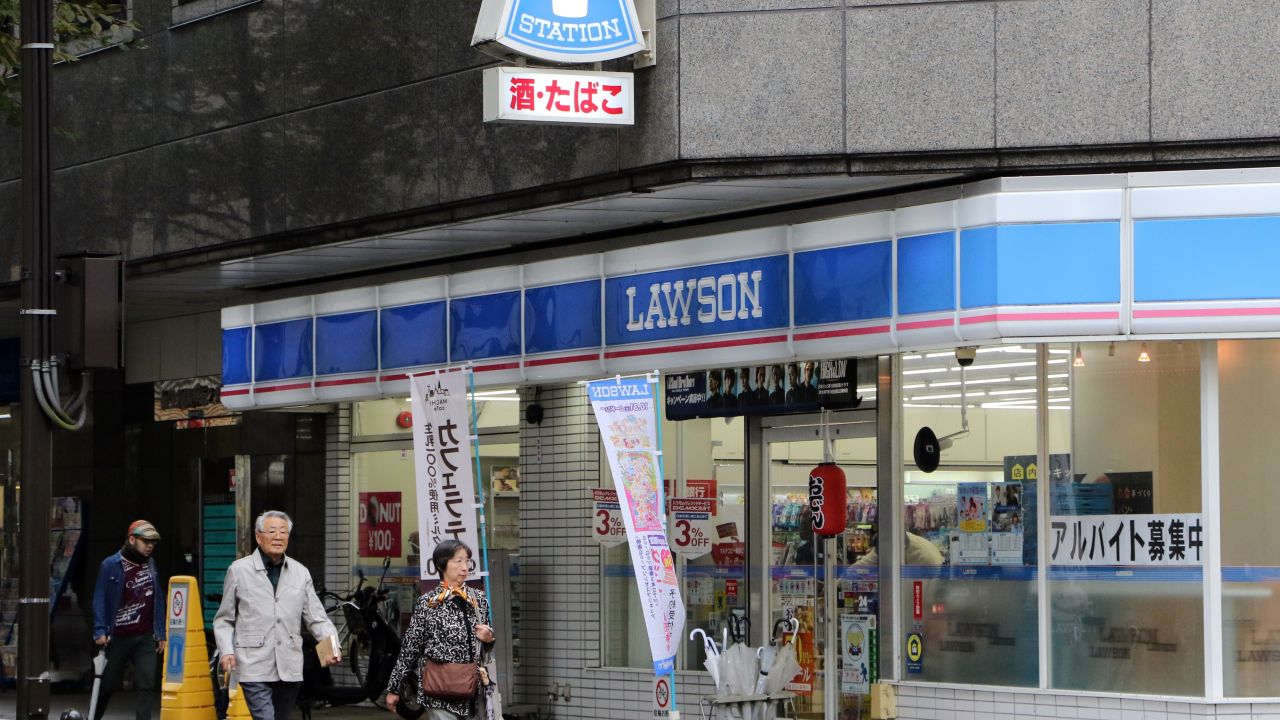 This 2015 image shows pedestrians walking past an outlet of Japan's second largest convenience chain, Lawson, in Yokohama, near the capital Tokyo.