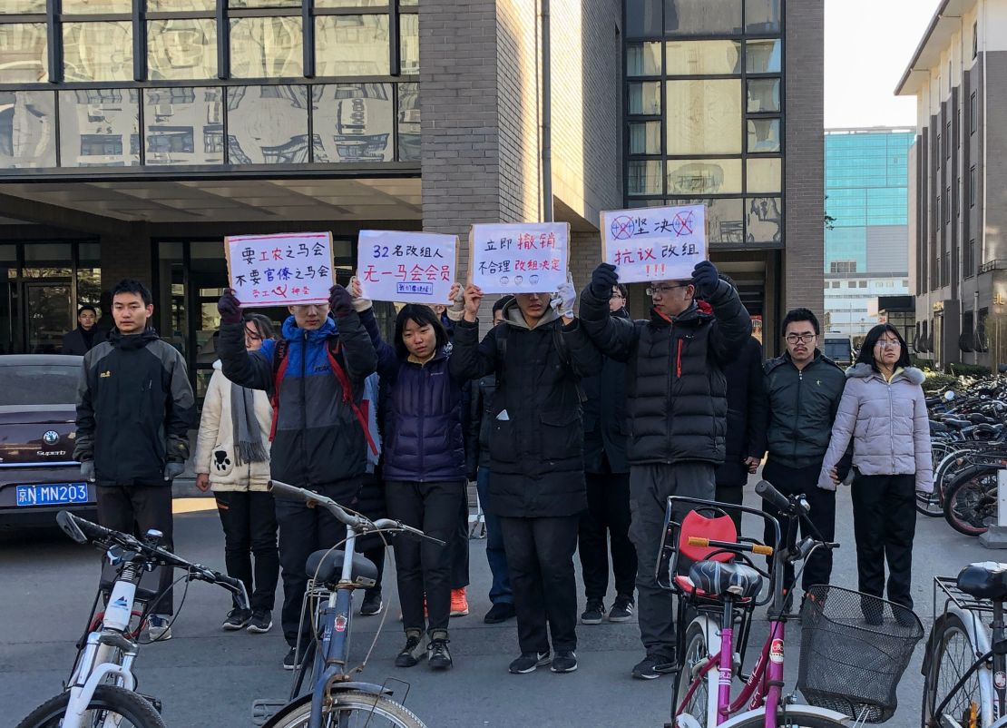A group of students hold up signs as they protest against the change in a student-run Marxist group's leadership at Peking University in Beijing on December 28, 2018.