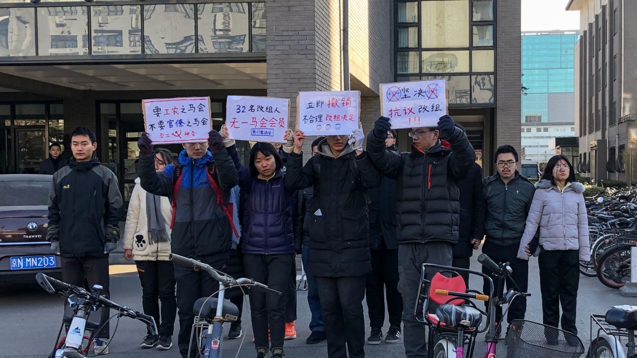 A group of students hold up signs as they protest against the change in a student-run Marxist group's leadership at Peking University in Beijing on December 28, 2018.