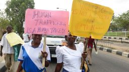Women carry placards at a protest march against violence, trafficking and child abuse on March 18, 2017 in Lagos.