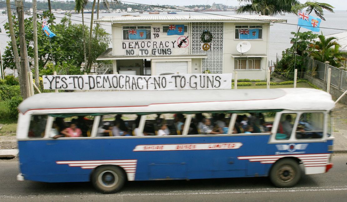 A bus passes by a house covered with anti-coup banners near Suva, the capital of Fiji, on December 6, 2006. Critics of the new law fear it could restore censorship. 