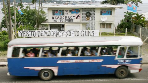 A bus passes by a house covered with anti-coup banners near Suva, the capital of Fiji, on December 6, 2006. Critics of the new law fear it could restore censorship. 