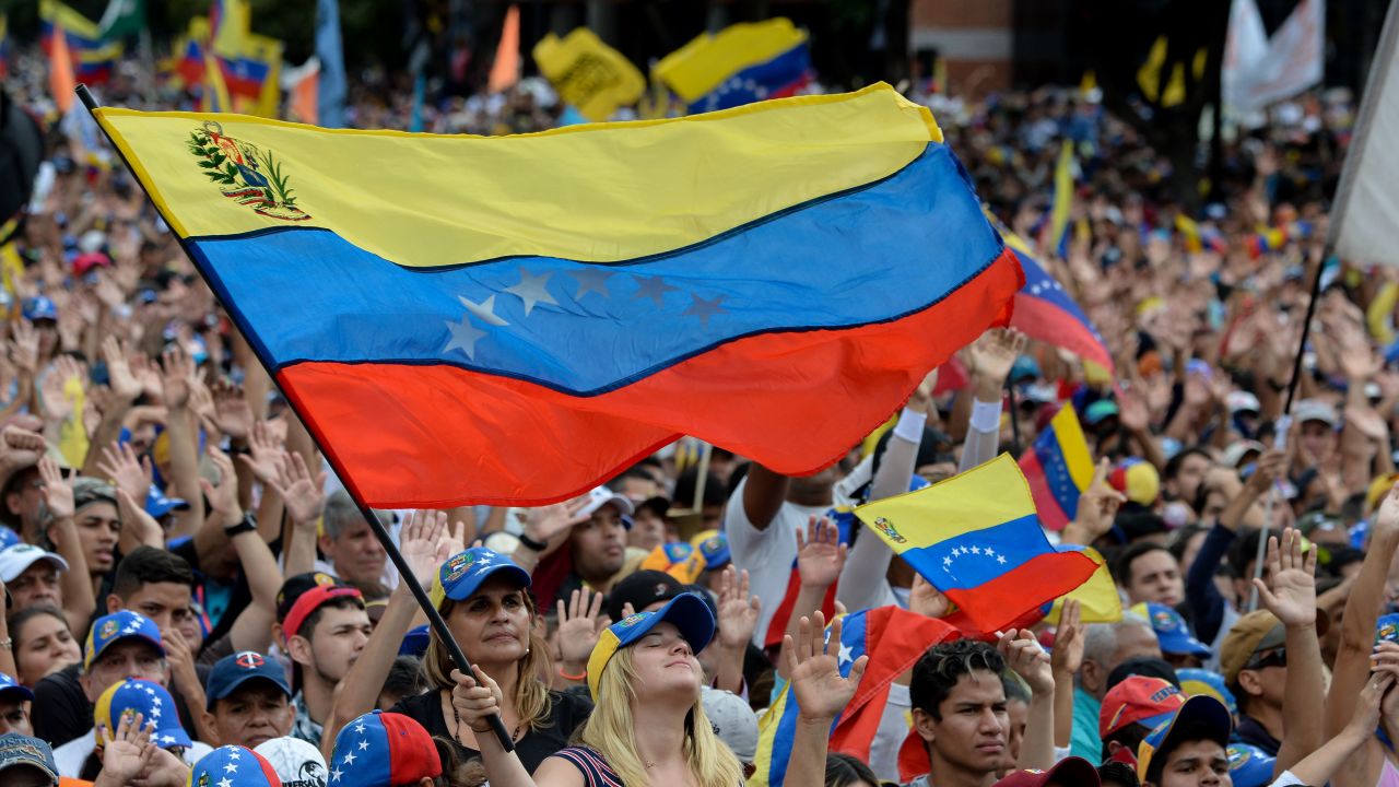 People cheer as they listen to Venezuela's National Assembly head Juan Guaido during a mass opposition rally against leader Nicolas Maduro.