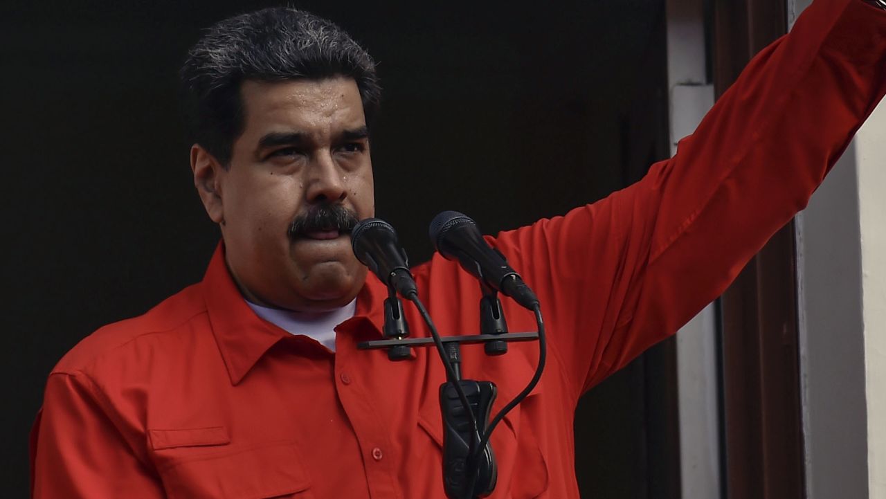 Venezuelan President Nicolas Maduro (C) speaks to a crowd of supporters at the Miraflores Palace flanked by his wife Cilia Flores (2-L) and Vice-President Delcy Rodriguez (R), as he holds up the document with which his government broke off diplomatic ties with the United States, during a gathering in Caracas on January 23, 2019. - Venezuelan President Nicolas Maduro announced on Wednesday he was breaking off diplomatic ties with the United States after his counterpart Donald Trump acknowledged opposition leader Juan Guaido as the South American country's "interim president." (Photo by Luis ROBAYO / AFP)        (Photo credit should read LUIS ROBAYO/AFP/Getty Images)