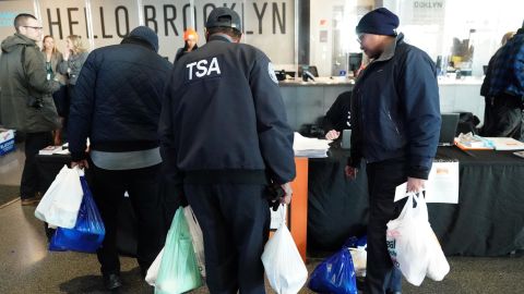 Furloughed TSA employees and others leave the Barclays Center in New York with bags of donated food.