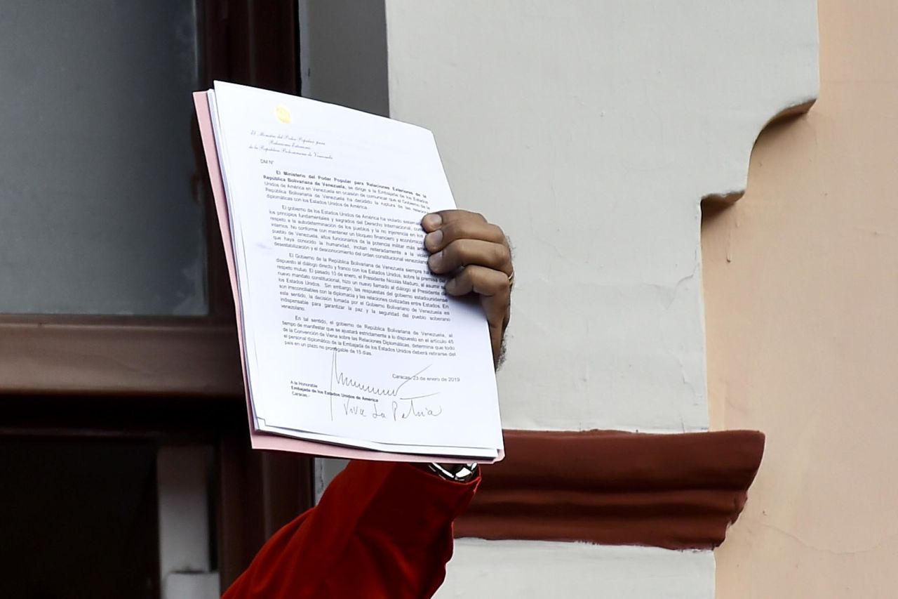 Maduro, speaking to a crowd of supporters at the Miraflores Palace in Caracas, holds up a document that says his government is breaking off diplomatic ties with the United States. "We cannot accept the invasive policies of the empire, the United States, the policies of Donald Trump," he said to cheers from the crowd on January 23. "Venezuela is a land of liberators."