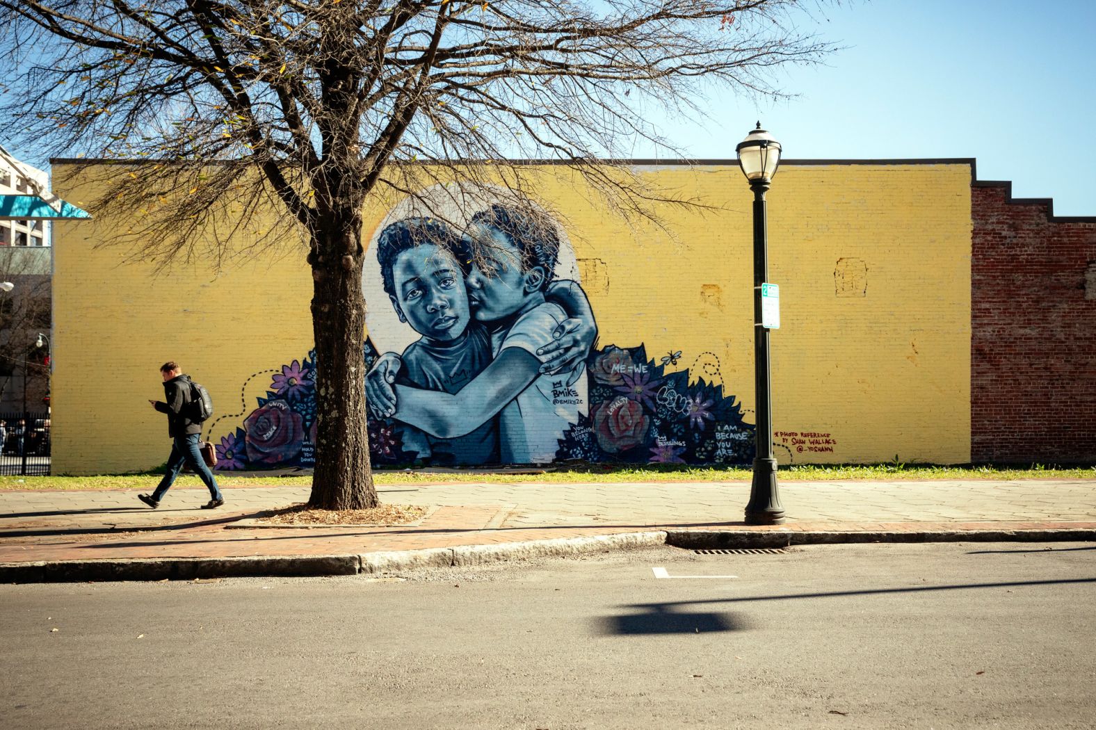 New Orleans artist Brandan "B-Mike" Odums created this mural, "<strong>Love and Protection</strong>," on Mitchell Street. With the words "Me = We" written next to a portrait of two kids hugging, Odums celebrates the power of friendship and togetherness.