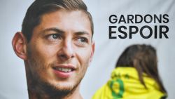 An FC Nantes supporter stands beside a portrait of Argentinian striker Emiliano Sala prior to a team training session at the training centre La Joneliere in La Chapelle-sur-Erdre, western France, on January 24, 2019, three days after the plane carrying Sala vanished over the English Channel. - Police on January 24 ended their search for new Premier League player Emiliano Sala, saying the chances of finding the Argentine alive three days after his plane went missing over the Channel were "extremely remote". Sala, 28, was on his way from Nantes in western France to the Welsh capital to train with his new teammates for the first time after completing a £15 million ($19 million) move to Cardiff City from French side Nantes on January 19. (Photo by LOIC VENANCE / AFP)        (Photo credit should read LOIC VENANCE/AFP/Getty Images)