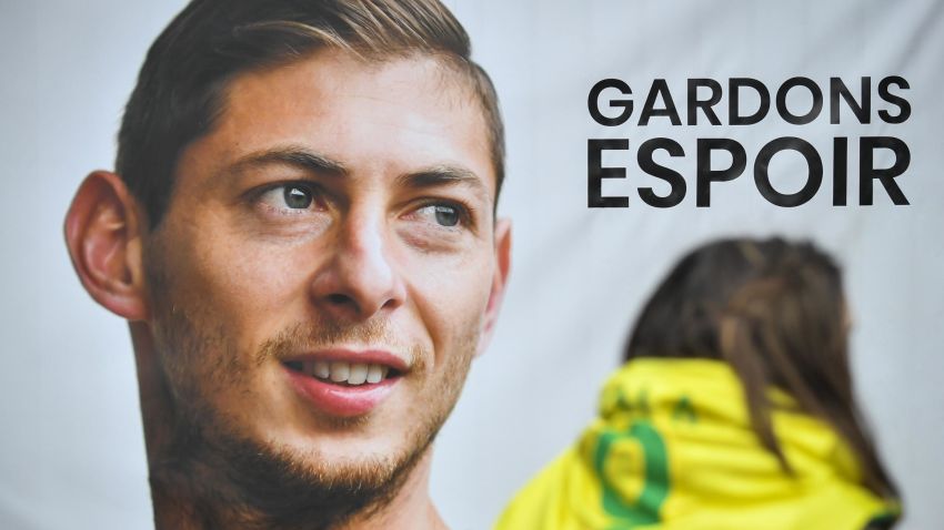 An FC Nantes supporter stands beside a portrait of Argentinian striker Emiliano Sala prior to a team training session at the training centre La Joneliere in La Chapelle-sur-Erdre, western France, on January 24, 2019, three days after the plane carrying Sala vanished over the English Channel. - Police on January 24 ended their search for new Premier League player Emiliano Sala, saying the chances of finding the Argentine alive three days after his plane went missing over the Channel were "extremely remote". Sala, 28, was on his way from Nantes in western France to the Welsh capital to train with his new teammates for the first time after completing a £15 million ($19 million) move to Cardiff City from French side Nantes on January 19. (Photo by LOIC VENANCE / AFP) (Photo credit should read LOIC VENANCE/AFP/Getty Images)