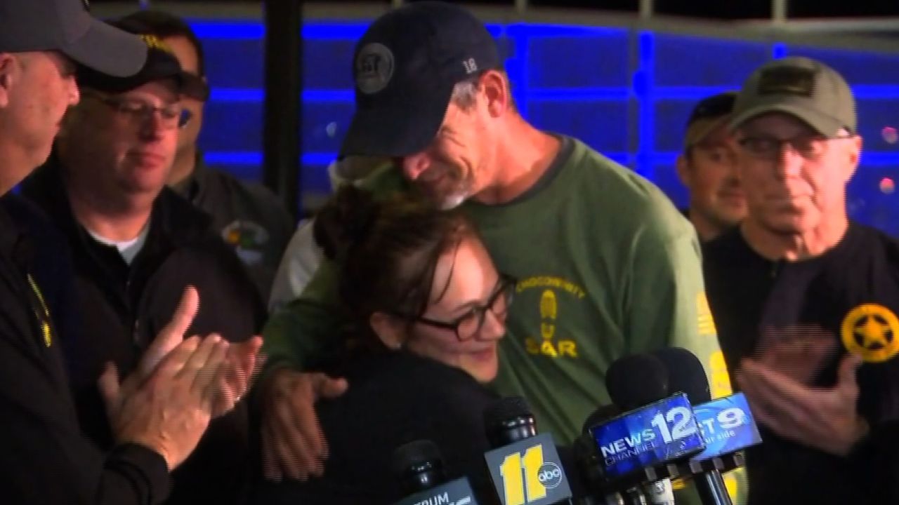 Casey's mother hugs the captain who heard the 3-year-old calling out from the bushes he was trapped in.