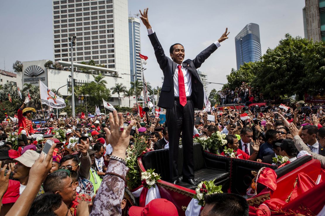 Jokowi waves to the crowd while on his journey to Presidential Palace following his election in October 2014.