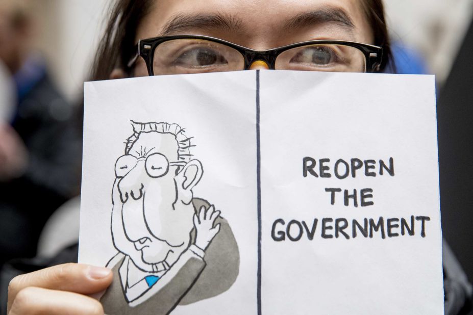 A furloughed worker displays a sign that reads "Reopen the Government" during a protest in Washington on January 23.
