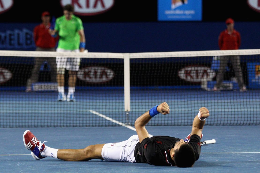 Novak Djokovic celebrates at the 2012 Australian Open while Rafael Nadal walks to the net. 