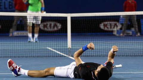 Novak Djokovic celebrates at the 2012 Australian Open while Rafael Nadal walks to the net. 
