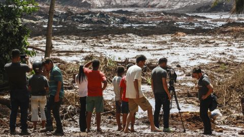 People observe the mud masses Friday after the break of the dam at the Feijao mine.