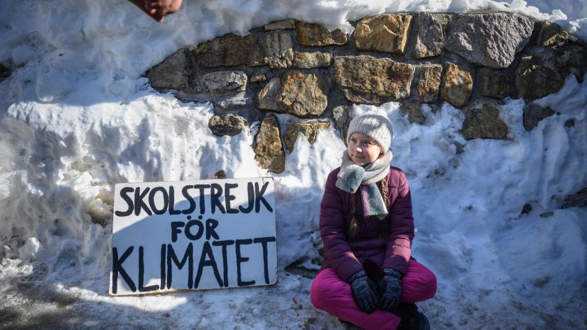 TOPSHOT - Swedish youth climate activist Greta Thunberg sits next to a placard reading "school strike for climate" on the sidelines of the World Economic Forum (WEF) annual meeting, on January 25, 2019 in Davos, eastern Switzerland. - Swedish 16-year-old Greta Thunberg has inspired a wave of climate protests by schoolchildren around the world after delivering a fiery speech at the UN climate summit in Katowice, Poland last month. (Photo by Fabrice COFFRINI / AFP)        (Photo credit should read FABRICE COFFRINI/AFP/Getty Images)