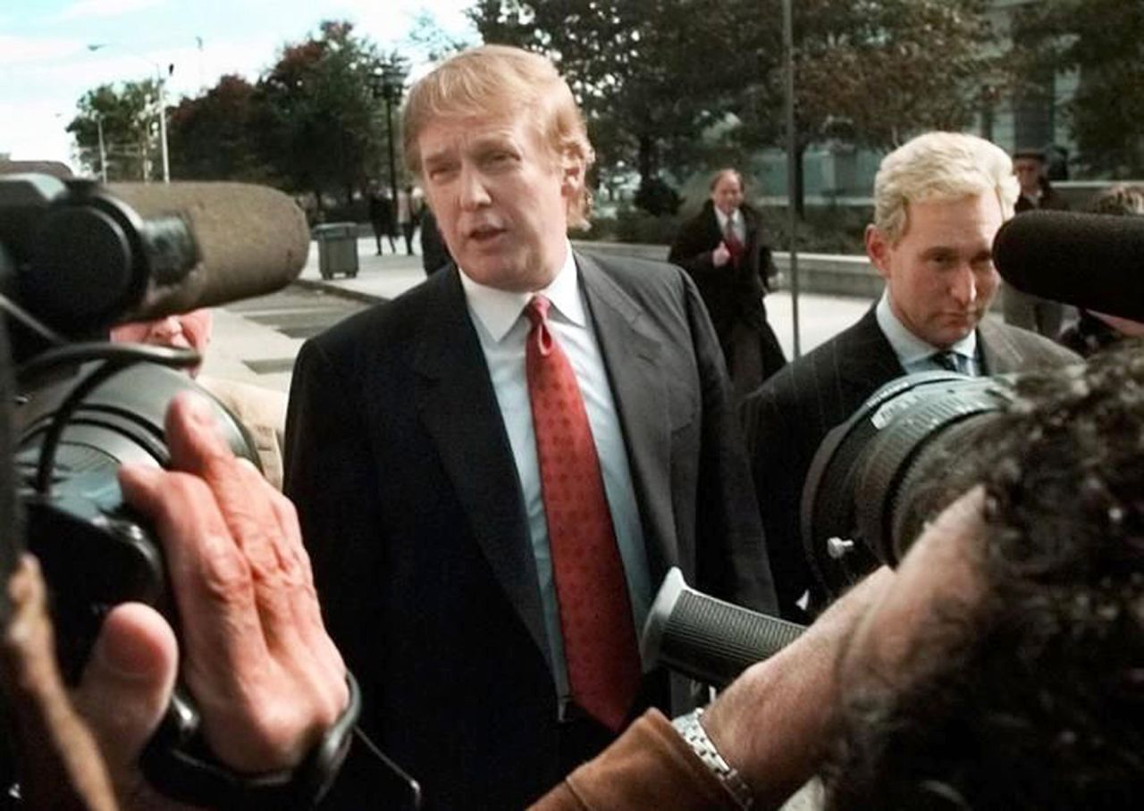 Donald Trump, next to Stone, speaks to reporters outside the federal courthouse in Newark, New Jersey, in October 1999. Stone was director of Trump's presidential exploratory committee. They were at the courthouse for the swearing-in of Trump's sister as a federal appeals court judge.