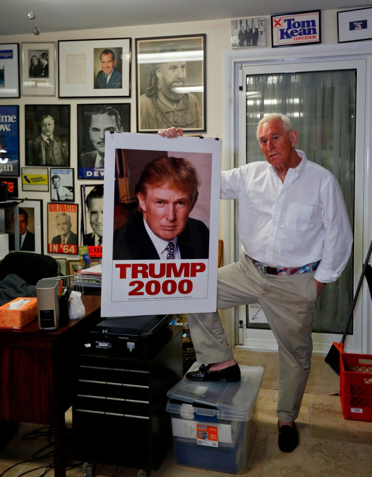 Stone poses with a 2000 poster of Donald Trump in his office in Florida.