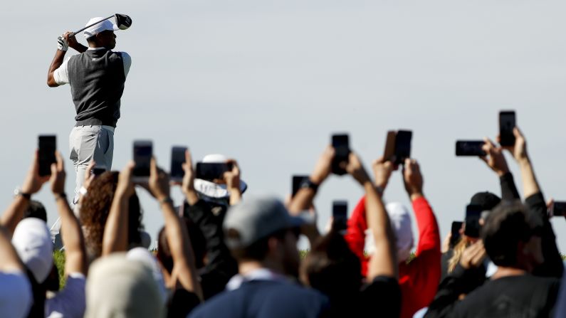Golf fans get a shot of Tiger Woods' tee shot during the first round of the Farmers Insurance Open on Thursday, January 24.