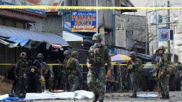 Policemen and soldiers keep watch as body bags (in white), containing the remains of blast victims, as seen in a cordoned area outside a church in Jolo, Sulu province on the southern island of Mindanao, on January 27, 2019. - At least 18 people were killed when two bombs hit a church on a southern Philippine island that is a stronghold of Islamist militants, the military said on January 27, days after voters backed the creation of a new Muslim autonomous region. (Photo by NICKEE BUTLANGAN / AFP)        (Photo credit should read NICKEE BUTLANGAN/AFP/Getty Images)