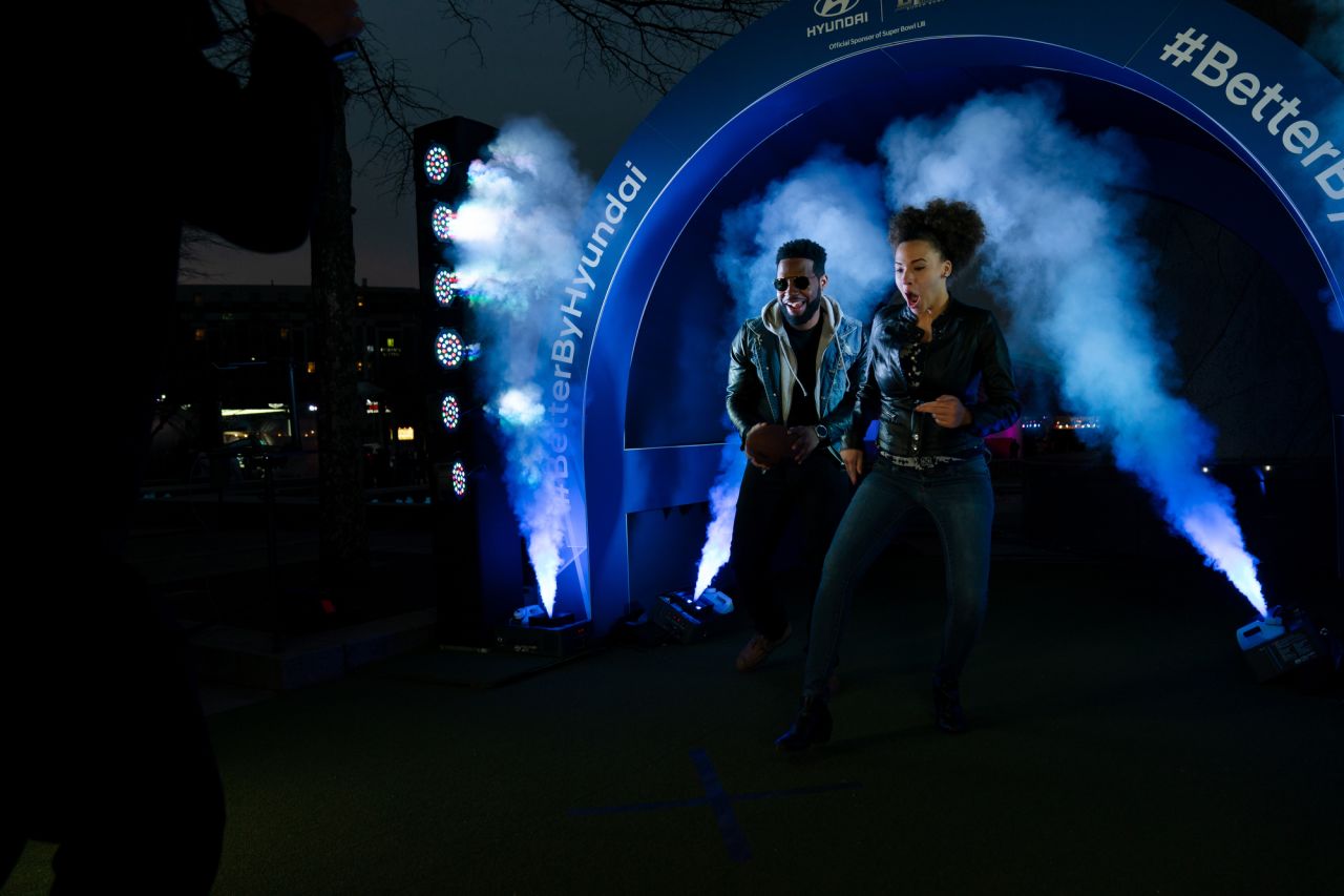 DeZwaan DeBois and his fiance, Barbara Manana, run through a replica player tunnel at Super Bowl LIVE in Centennial Park on Sunday. The couple, from Greenville, South Carolina, were in town visiting friends and family. "We were just at the park and didn't know this was happening, but we came to see what it was all about," DeBois said. "I've never been around a Super Bowl or to one, so this is pretty cool."