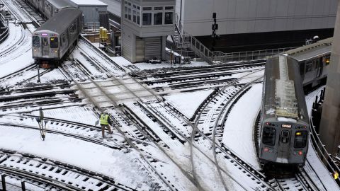 Chicago's L trains move along snow-covered tracks Monday.