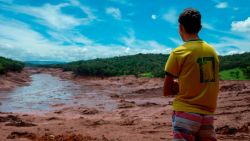TOPSHOT - A boy looks at an area in the community of Casa Grande affected by a sludge after the collapse, two days ago, of a dam at an iron-ore mine belonging to Brazil's giant mining company Vale near the town of Brumadinho, state of Minas Gerias, southeastern Brazil, on January 27, 2019. - Communities were devastated by a dam collapse that killed at least 37 people at a Brazilian mining complex -- with hopes fading for 250 still missing. A barrier at the site burst on Friday, spewing millions of tons of treacherous sludge and engulfing buildings, vehicles and roads. (Photo by Mauro PIMENTEL / AFP)        (Photo credit should read MAURO PIMENTEL/AFP/Getty Images)