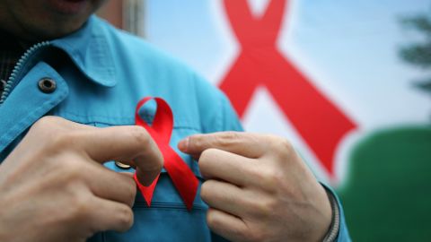 A man pins an HIV awareness ribbon to his shirt. The HIV-positive status of thousands of people was leaked from a Singaporean database this month.