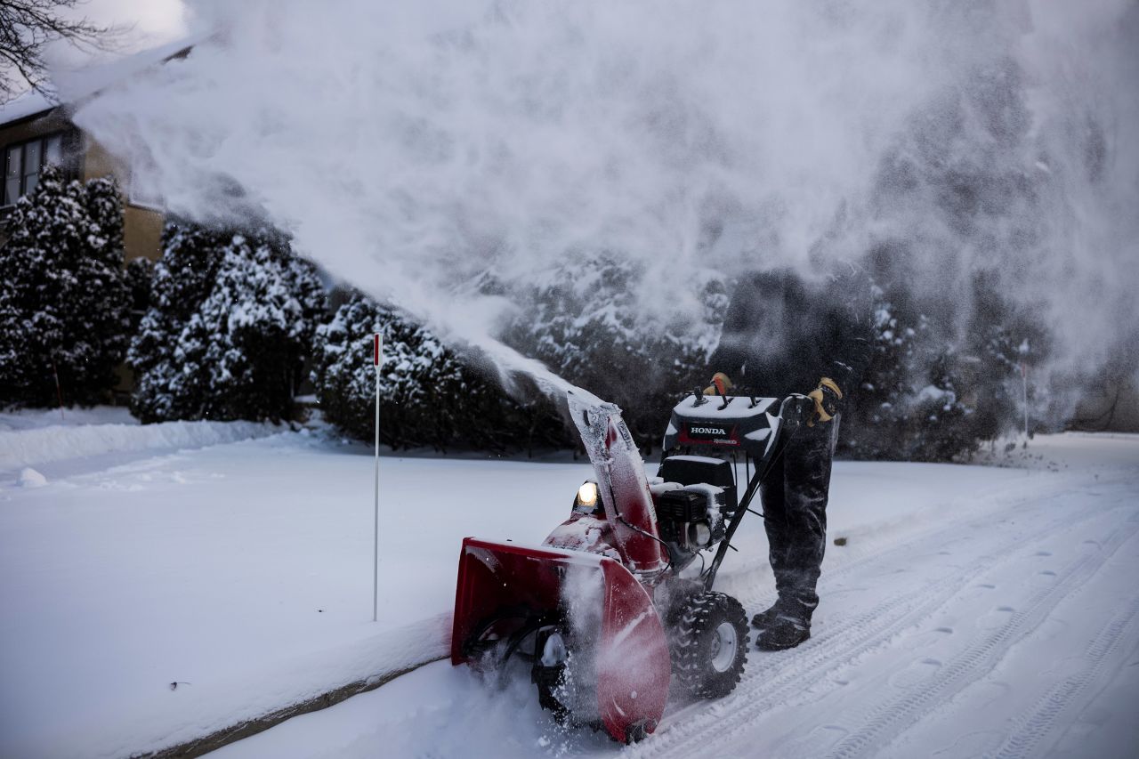Al Ross uses a snowblower on his driveway in Minneapolis.