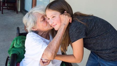 11-year-old Ruby Kate Chitsey gets kisses from a nursing home resident.