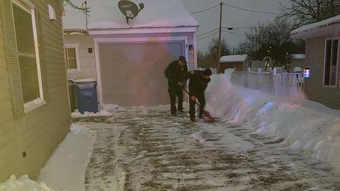 Iowa firefighters who were called to a home delivery shovel snow from the new parents' driveway.