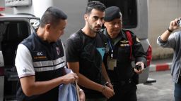Hakeem Alaraibi (C), a former Bahrain national team footballer with refugee status in Australia, is escorted by immigration police to a court in Bangkok on December 11, 2018. - Alaraibi was stopped by Thai immigration on November 27 after arriving in Bangkok from Australia for a vacation with his wife. (Photo by Lillian SUWANRUMPHA / AFP)        (Photo credit should read LILLIAN SUWANRUMPHA/AFP/Getty Images)
