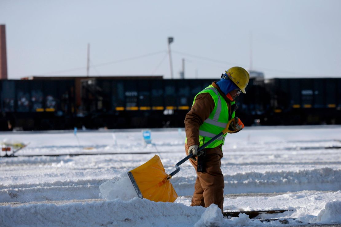 A worker shovels snow off the rail switches at the Metra Western Avenue Yard in Chicago. 