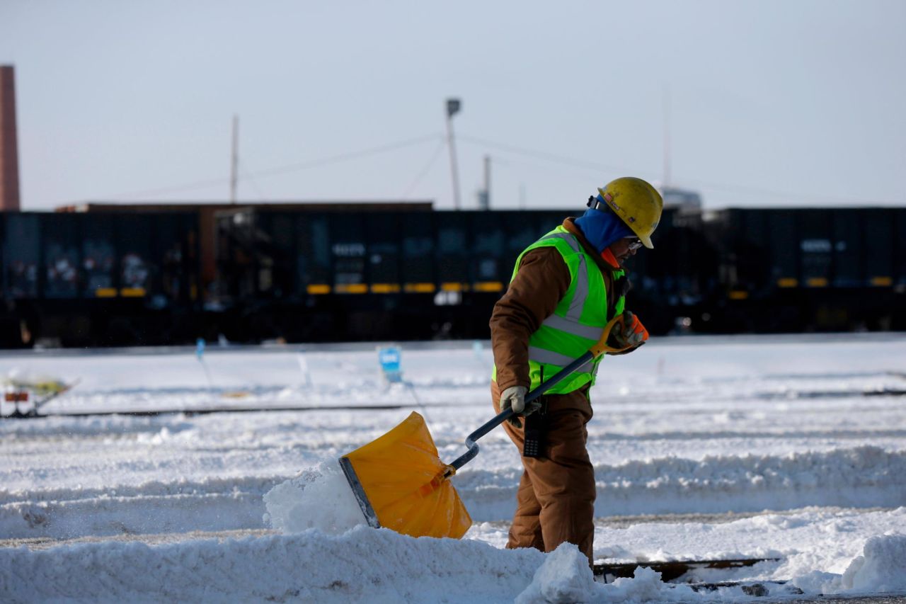 A worker shovels snow off the rail switches at the Metra Western Avenue Yard in Chicago on January 29.