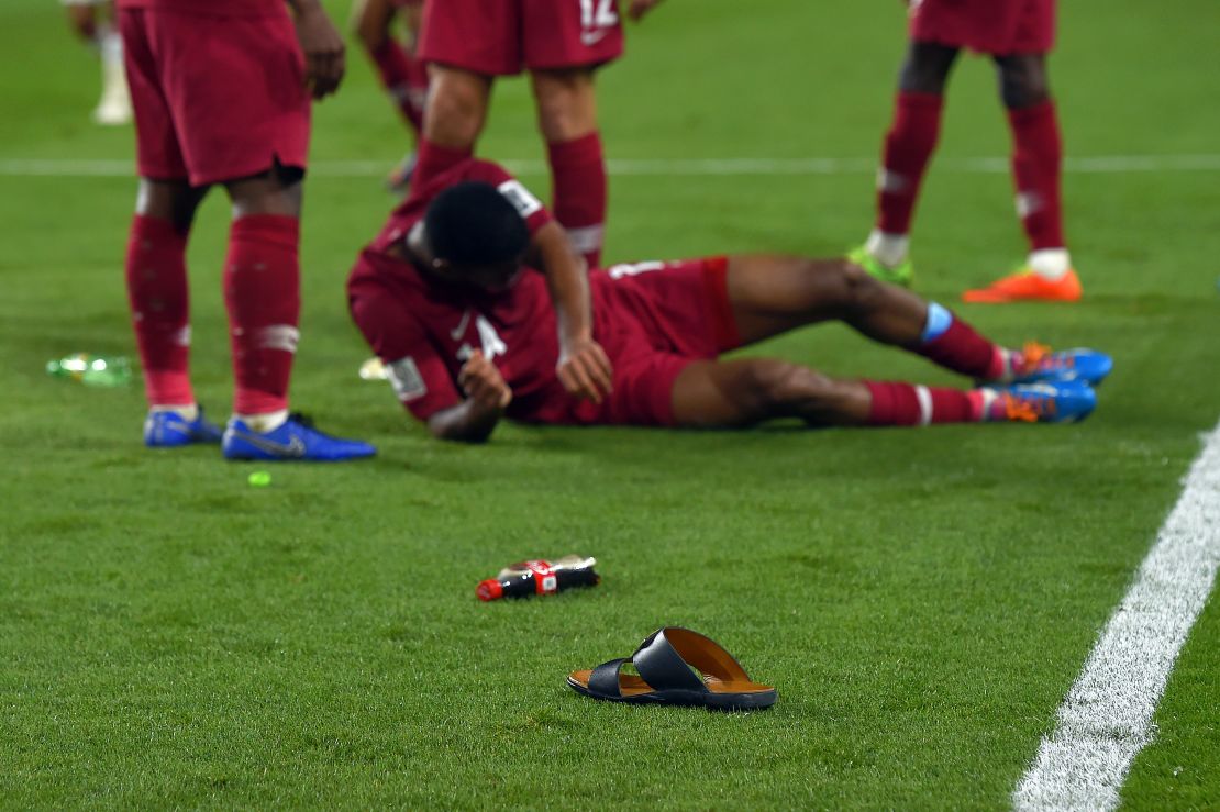 Objects are thrown onto the pitch after Qatar score their third goal during the semifinal. 