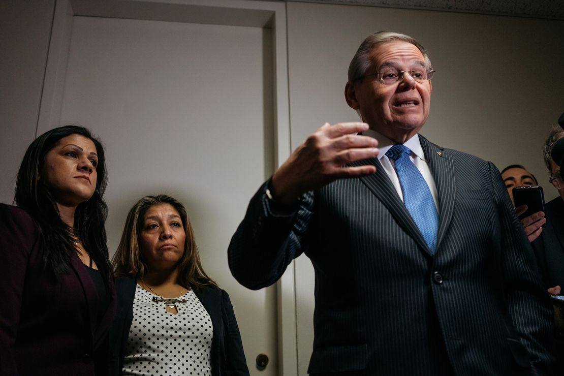 Sandra Diaz, left, and Victorina Morales stand by as Sen. Bob Menendez delivers remarks to reporters.